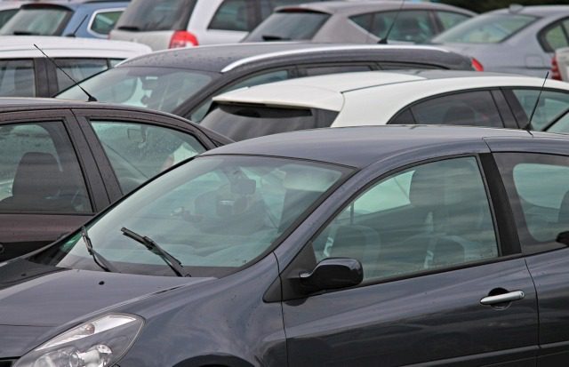 Cars parked closely in a crowded lot.