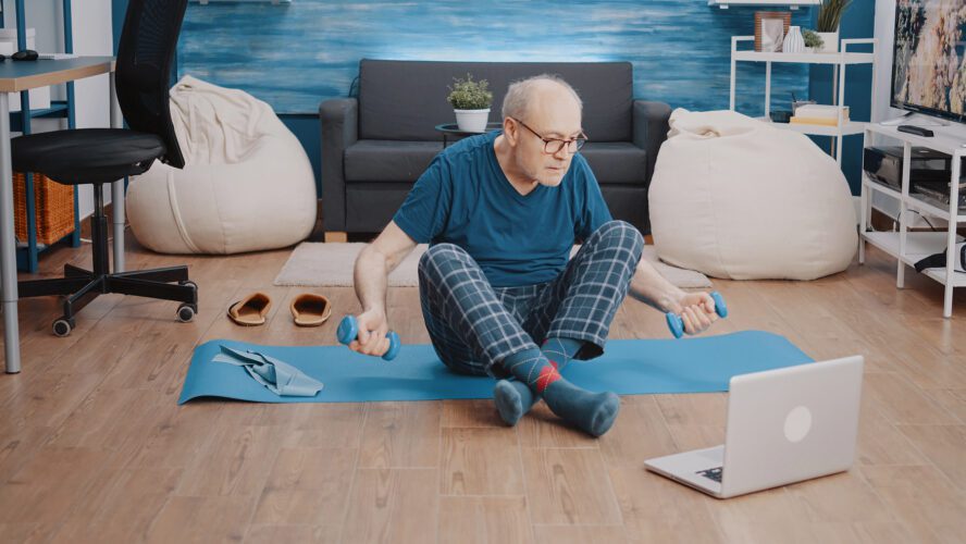 Man exercising with dumbbells in living room.