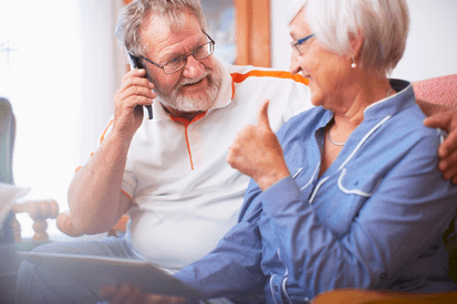 Two people smiling in dim lighting.