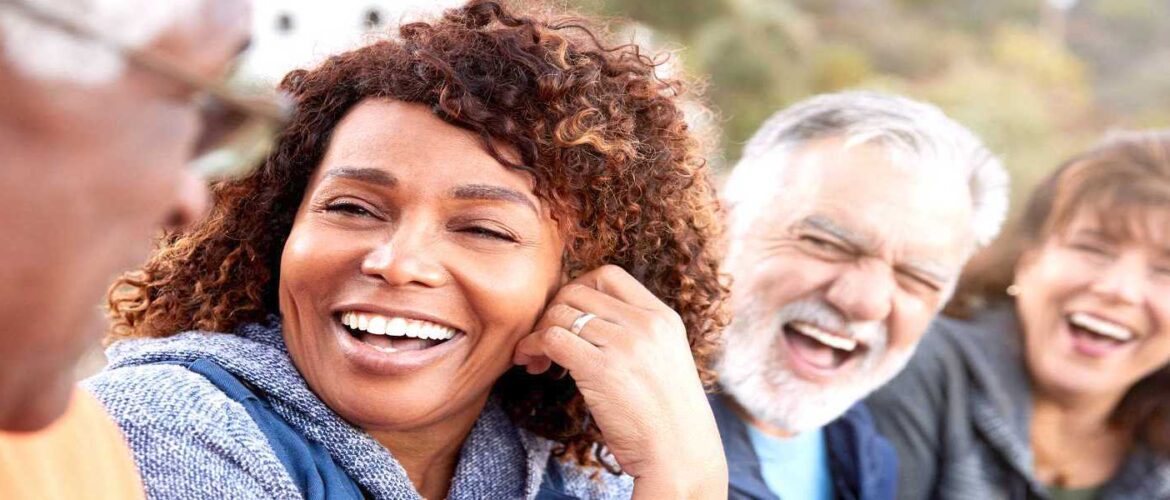 Group of people laughing together outdoors.