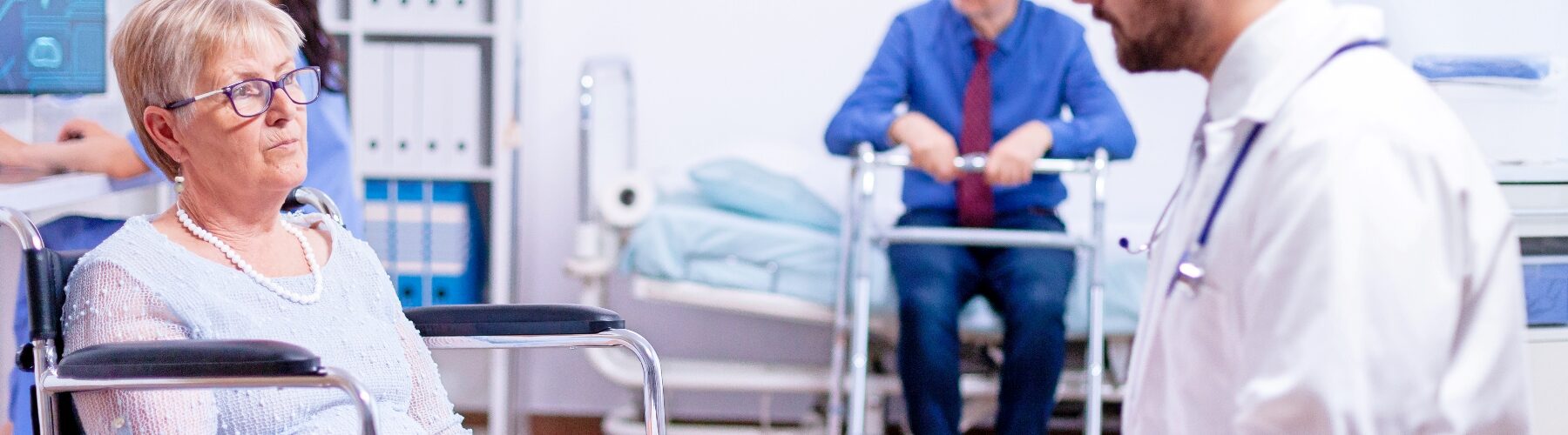 A patient discusses symptoms with a doctor in a medical office while another doctor listens.