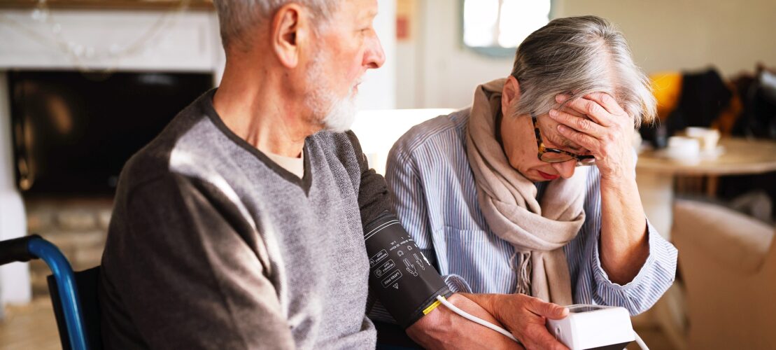Elderly couple checking blood pressure at home.