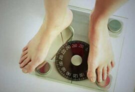 Feet standing on a bathroom scale.