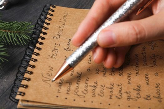 Handwriting New Year's resolutions in notebook.