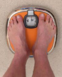 Feet on an orange bathroom scale.