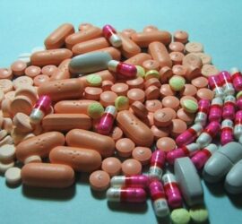 Various colorful pills and capsules on surface.