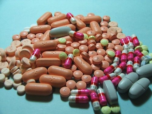 Various colorful pills and capsules on surface.