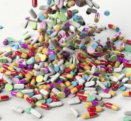 Colorful pills and tablets scattered on surface.
