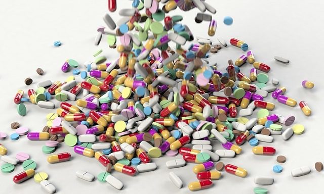 Colorful pills and tablets scattered on surface.