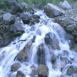 Small waterfall flowing over rocky terrain.