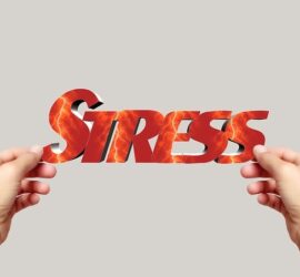 Hands holding the word 'STRESS' made of fiery material.