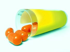Orange pills spilling from yellow container.