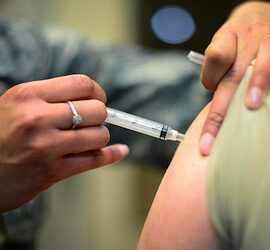 Person receiving a vaccine injection in the upper arm.