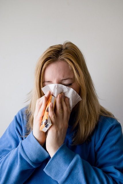 Person blowing their nose with a tissue.